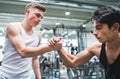 A friendly handshake of two young men in crossfit gym.