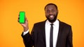 Friendly handsome afro-american man in suit showing prekeyed phone, template