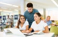 Friendly happy group of students preparing together for exam in university library Royalty Free Stock Photo