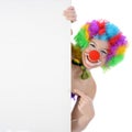 Friendly smiling clown pointing on blank poster with copy space in studio Royalty Free Stock Photo