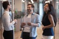 Friendly happy three diverse colleagues talking laughing at work break