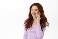 Friendly happy woman with red hair talking on mobile phone, having phone call and smiling relaxed, standing in casual Royalty Free Stock Photo