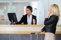 friendly hotel receptionist handing over key to customer Royalty Free Stock Photo