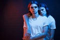 Friendly hug. Portrait of twin brothers. Studio shot in dark studio with neon light Royalty Free Stock Photo