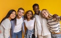 Friendly international students taking selfie over yellow background