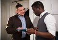 Friendly landlord signing agreement with positive man Royalty Free Stock Photo