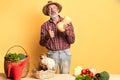 Friendly local male farmer with gray beard, shows thumbs up, holds pumpkin