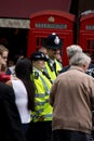 Happy smiling Metropolitan police officers interacting with a Pearly King in London, England Royalty Free Stock Photo