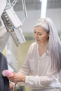 Friendly longhaired woman cleaning jacket in dry cleaning Royalty Free Stock Photo