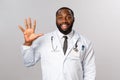 Friendly-looking cheerful handsome african-american doctor, male physician showing five, fifth number with hand, smiling