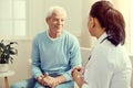 Friendly looking retired man smiling while listening to doctor Royalty Free Stock Photo