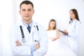 Friendly male doctor on the background with patient in the bed and his physician Royalty Free Stock Photo