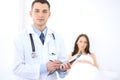 Friendly male doctor on the background with patient in the bed and his physician Royalty Free Stock Photo