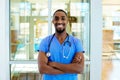 Friendly male doctor or nurse wearing blue scrubs uniform and stethoscope,