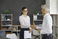 Friendly male and female business partners shake hands to confirm their partnership. Royalty Free Stock Photo