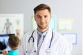 Friendly male general practitioner standing in office