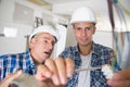 Friendly master electrician and apprentice working on breaker panel Royalty Free Stock Photo