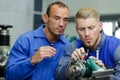 friendly master electrician and apprentice working on breaker panel Royalty Free Stock Photo