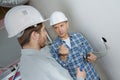 Friendly master electrician and apprentice working Royalty Free Stock Photo