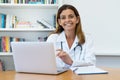 Friendly mature adult female doctor at work at office Royalty Free Stock Photo