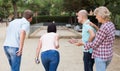 friendly mature couples playing petanque at leisure