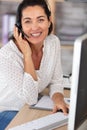 friendly middle aged woman wearing head set in office