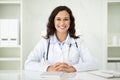 Friendly millennial caucasian woman doctor sitting at desk