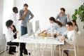 Friendly multi-ethnic team having lunch together eating pizza in Royalty Free Stock Photo