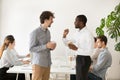 Friendly multiracial colleagues chatting together in office duri Royalty Free Stock Photo