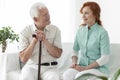 Friendly nurse talking with smiling elderly man with walking sti Royalty Free Stock Photo