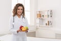 Friendly nutritionist holding fresh fruit, copy space