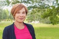 Friendly older woman closeup portrait. Healthy happy elegant elderly woman with red short haircut smiling Royalty Free Stock Photo