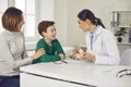 Pediatric dentist consults mother with her young son in the office of a modern dental clinic. Royalty Free Stock Photo