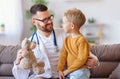 Friendly pediatrician doctor shows Teddy bear to patient little boy Royalty Free Stock Photo