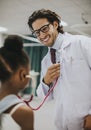 Friendly pediatrician entertaining his patient Royalty Free Stock Photo