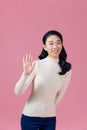 Friendly, pleasant and cheerful east-asian woman raising palm, wave hand greeting and smiling on pink background