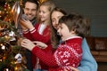 Friendly positive caucasian family decorating Christmas tree. Royalty Free Stock Photo