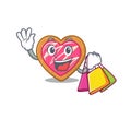 A friendly rich cookie heart waving and holding Shopping bag