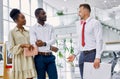 Friendly salesman and beautiful couple in car showroom