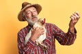 Friendly senior farmer looking proudly at fresh egg, holding in hand hen Royalty Free Stock Photo