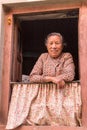 Friendly senior Nepalese woman in the window of her house in Kirtipur Royalty Free Stock Photo