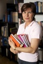 Friendly senior woman holding books