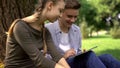 Friendly siblings scrolling pages on tablet, social networks and online games