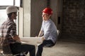 Friendly smiling builders` team resting on the chairs