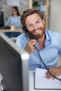 Friendly smiling businessman on telephone at desk Royalty Free Stock Photo