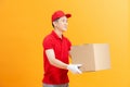 Friendly smiling courier giving out package for customers, handing box to client Royalty Free Stock Photo