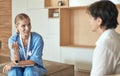 Friendly smiling doctor and patient sitting on the couch. Very good news and high level medical care concept. Royalty Free Stock Photo