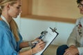 Friendly smiling doctor and patient sitting on the couch. Very good news and high level medical care concept. Royalty Free Stock Photo