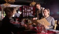 Friendly smiling female waiter bringing order to visitors in luxurious restaurant Royalty Free Stock Photo