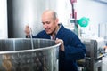 Mature man working in wine fermentation section. Royalty Free Stock Photo